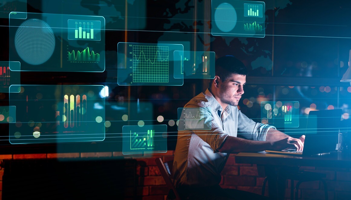 A professional at the Department of Defense sits at a computer in a dark operation center highlighting real time analytics, decision-making, and mission critical intelligence.