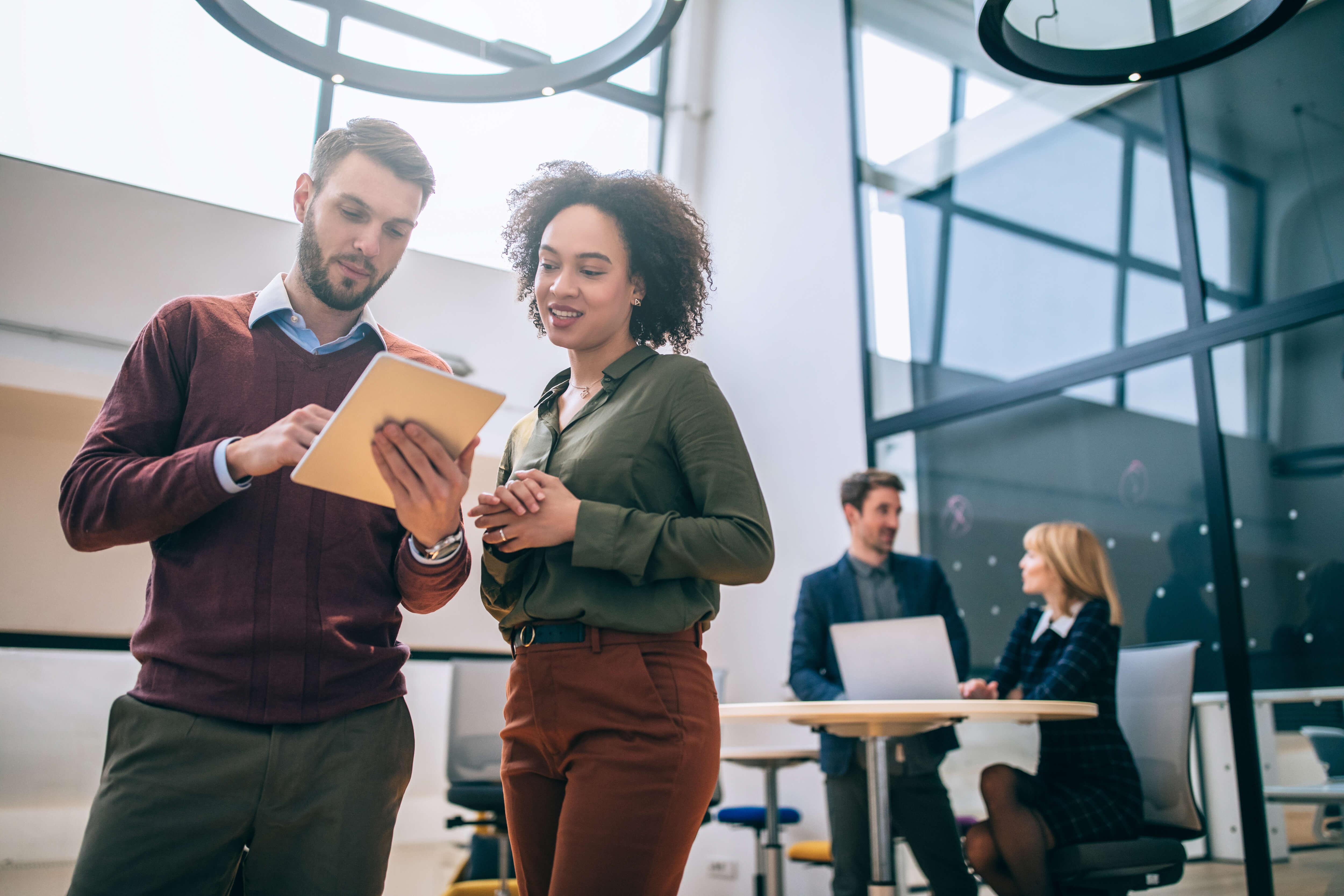 Man and woman coworkers looking at a tablet in the office