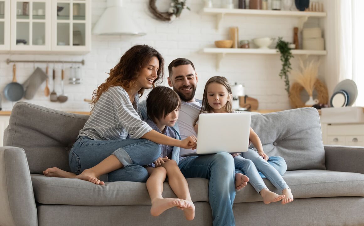 Family on couch looking at laptop.