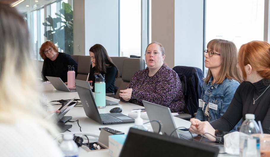 The Maximus Corporate Communications team sitting around a table having a meeting.