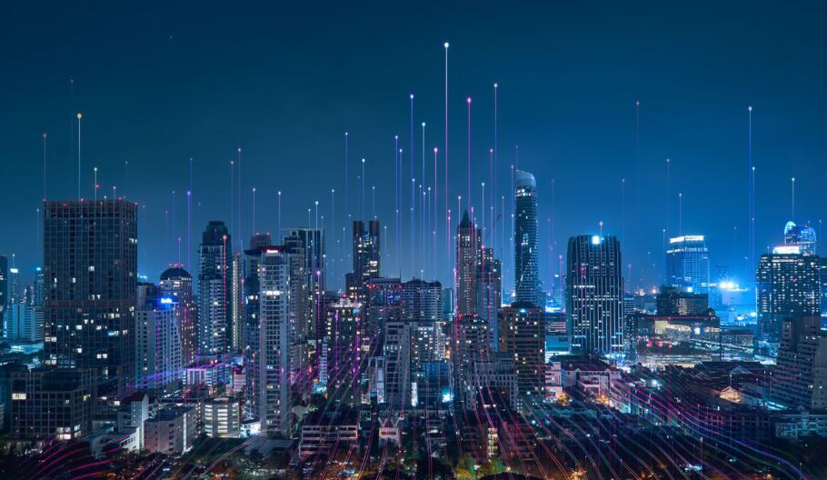 Nighttime city skyline with bright light lines in the sky.