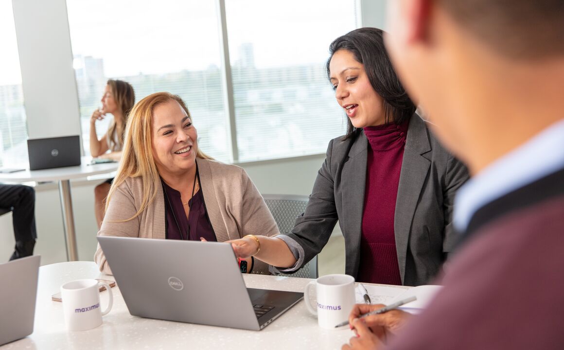 Employees looking at a laptop and talking